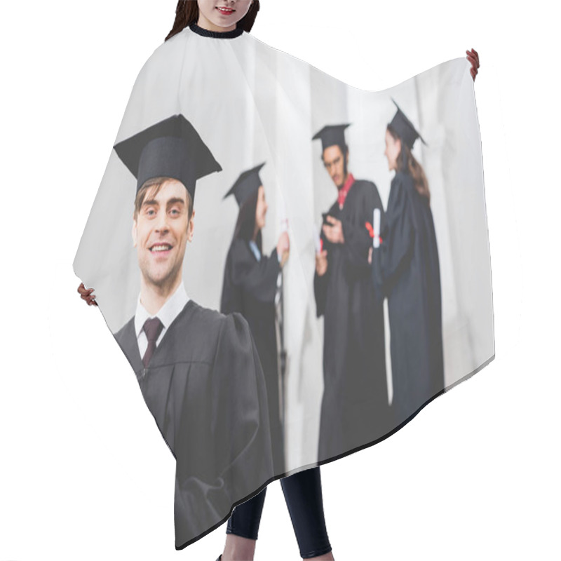 Personality  Selective Focus Of Happy Man In Graduation Gown Looking At Camera And Holding Diploma Near Students  Hair Cutting Cape