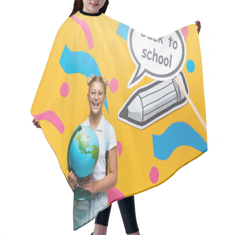 Personality  Schoolchild With Globe Looking At Camera Near Paper Art With Back To School Lettering On Yellow Background Hair Cutting Cape