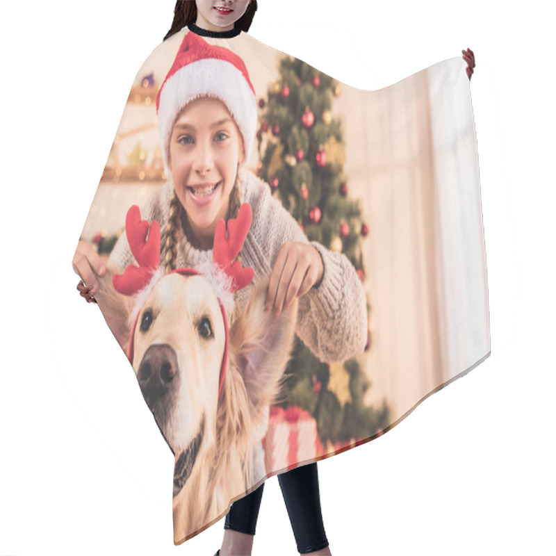 Personality  Smiling Kid In Santa Hat And Golden Retriever Dog With Deer Horns Having Fun At Home Near Christmas Tree Hair Cutting Cape