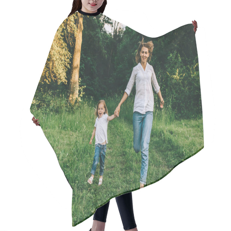 Personality  Young Mother And Cheerful Daughter Holding Hands While Running Together In Forest Hair Cutting Cape