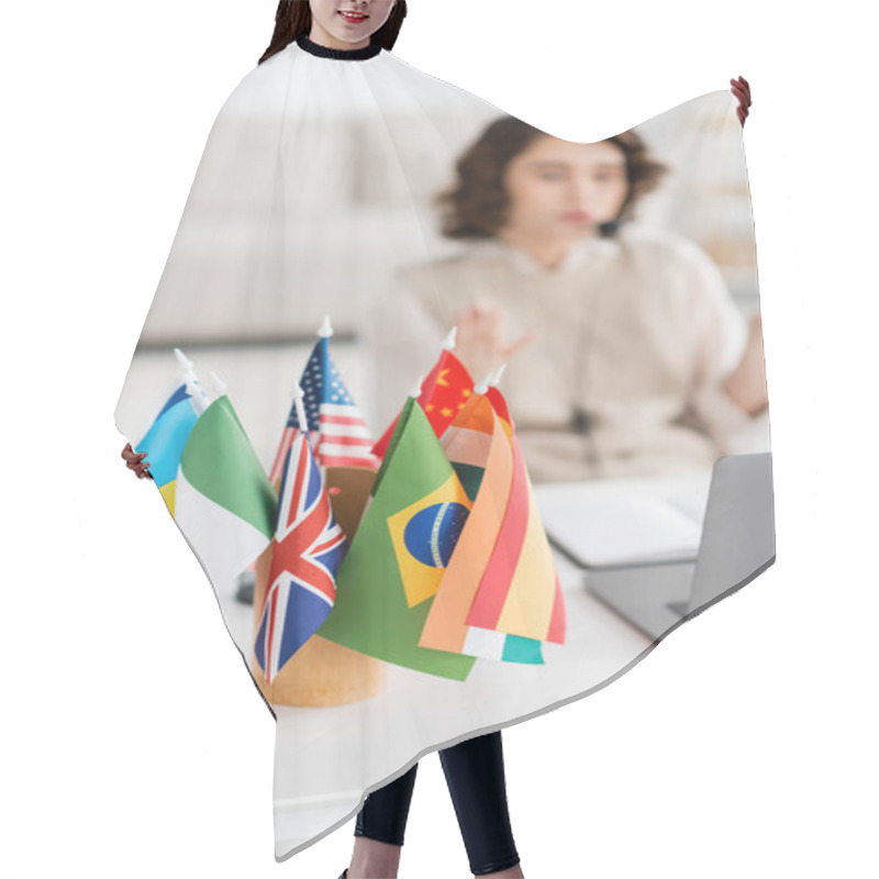 Personality  Selective Focus Of International Flags Near Blurred Laptop And Young Language Teacher Working At Home Hair Cutting Cape