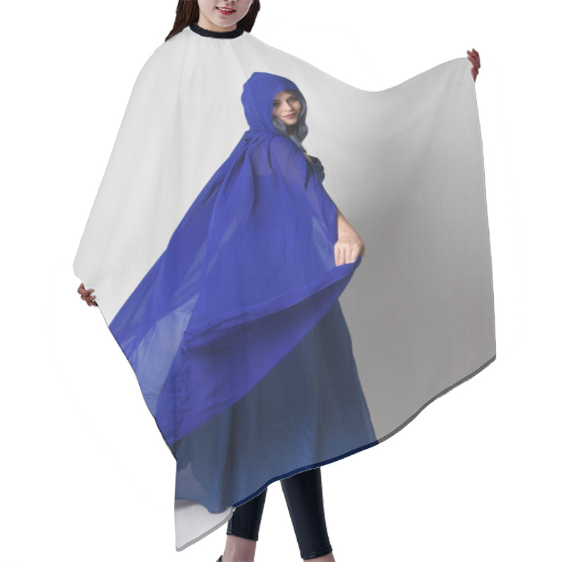 Personality  Full Length Portrait Of Beautiful Young Female Model Elegant Blue Fantasy  Ball Gown And Flowing Cape With Hood. Standing Pose, Walking Away Facing Backwards. Isolated On Whit Studio Background. Hair Cutting Cape