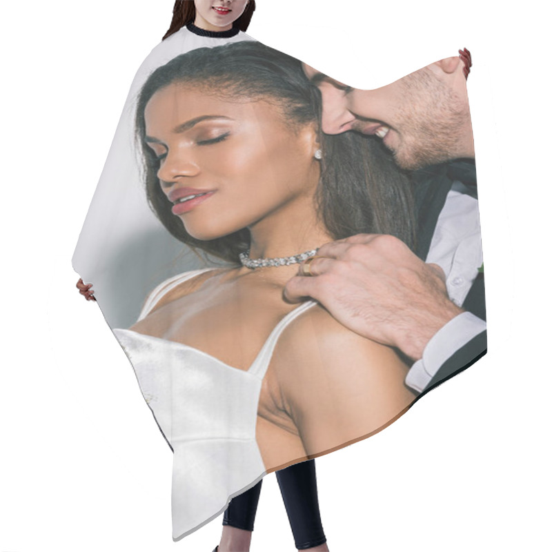 Personality  Happy Bridegroom Touching Shoulder Of Beautiful African American Bride Holding Wedding Bouquet With Closed Eyes On White Background Hair Cutting Cape