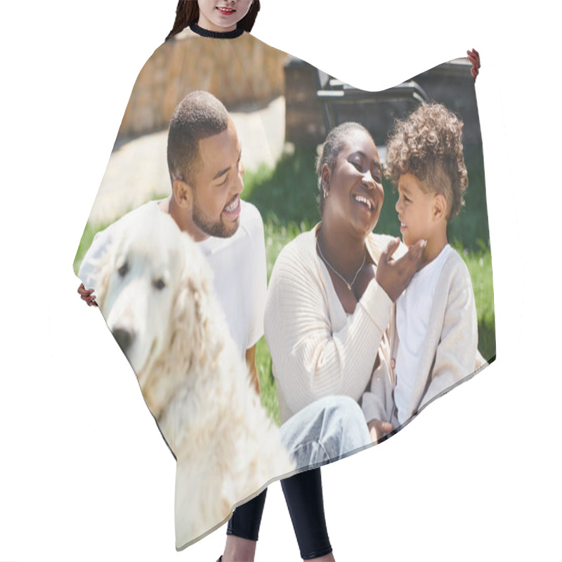 Personality  Family Portrait Of Cheerful African American Family Smiling And Sitting On Lawn Near Dog Hair Cutting Cape