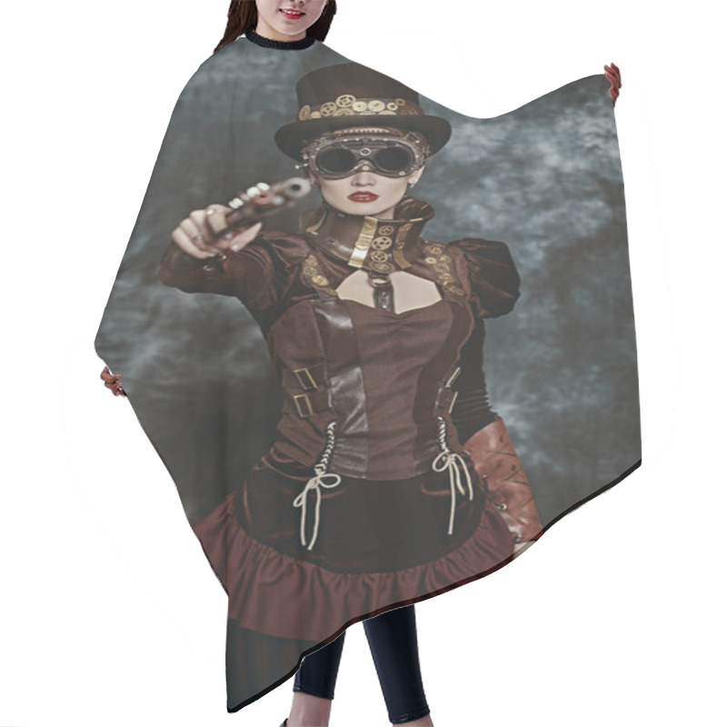 Personality  Confident Girl Aims A Gun At The Camera Against The Background Of Grunge. Steampunk Concept.  Hair Cutting Cape