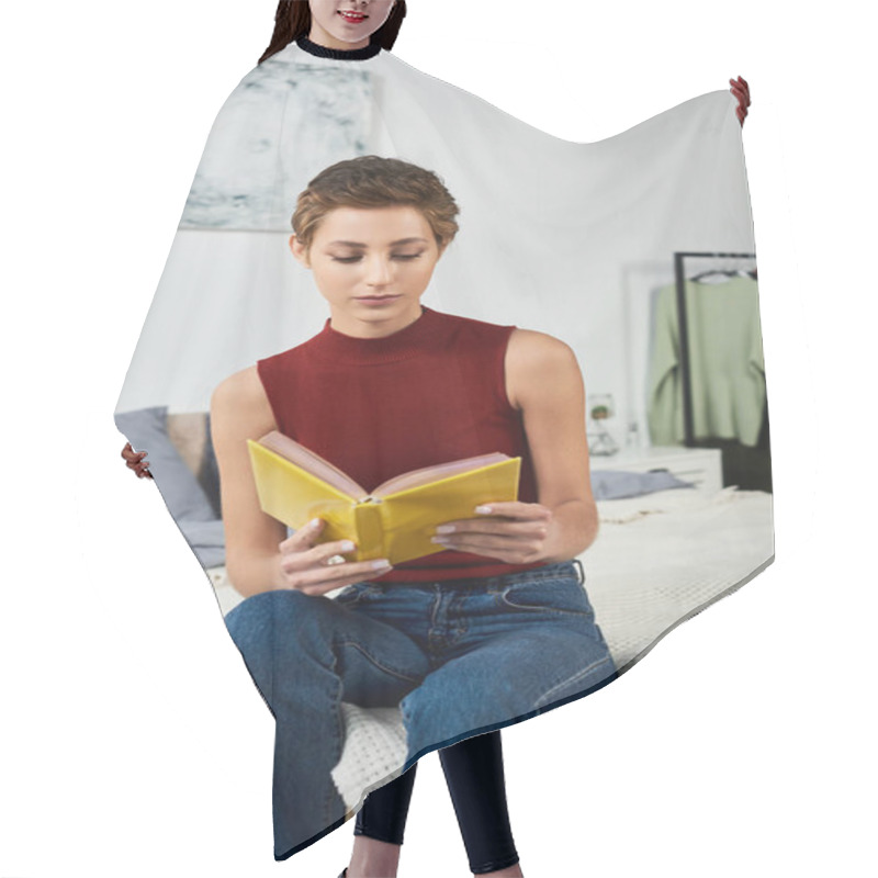 Personality  A Young Woman With Short Hair Relaxes At Home, Immersed In A Captivating Book While Sitting In Her Bedroom. Hair Cutting Cape