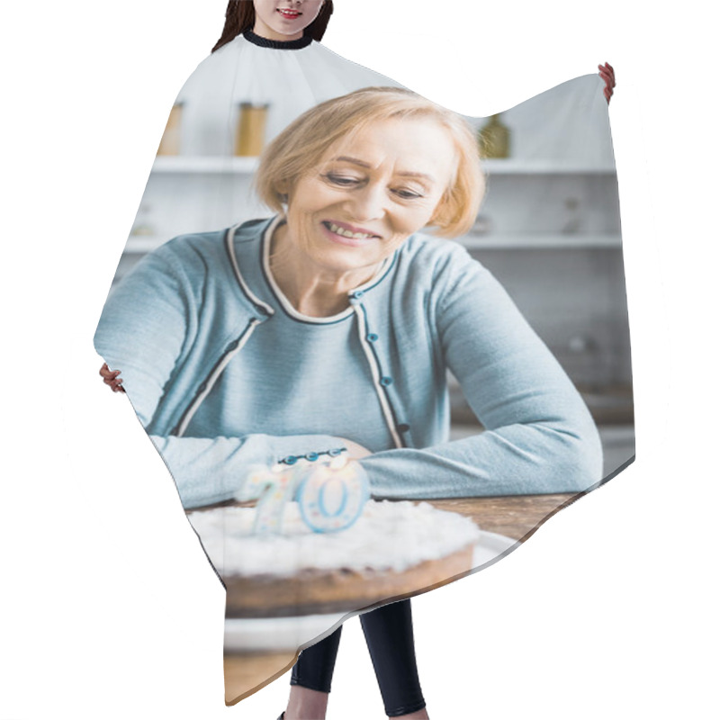 Personality  Senior Woman Sitting At Table And Looking At Cake With '70' Sign During Birthday Celebration At Home Hair Cutting Cape