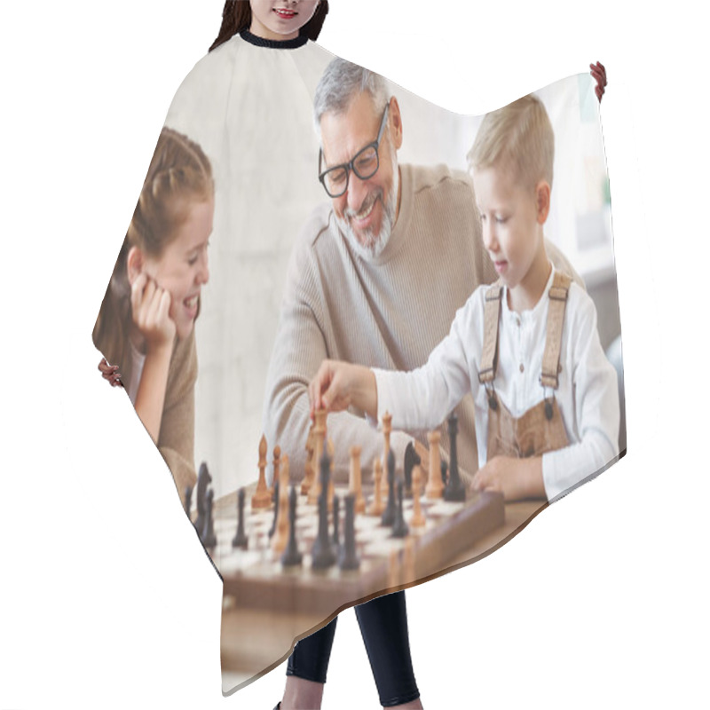 Personality  Joyful Children Brother And Sister Playing Chess While Sitting In Living Room With Senior Grandparents While Spending Time Together On Weekend, Kids Sitting At Table With Chessboard And Smiling Hair Cutting Cape