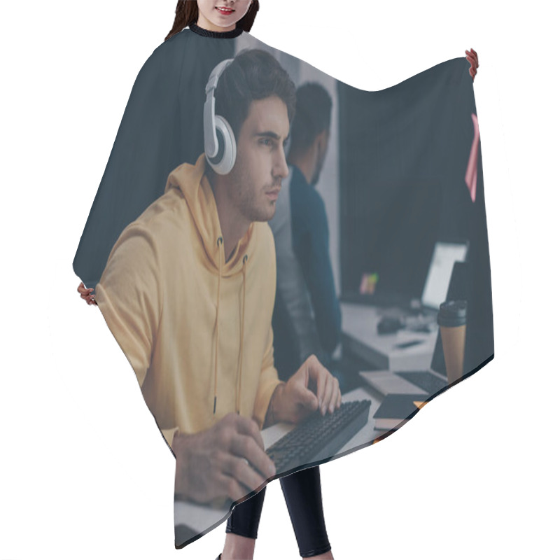 Personality  Selective Focus Of Programmer In Headphones Working Near African American Colleague At Night In Office Hair Cutting Cape