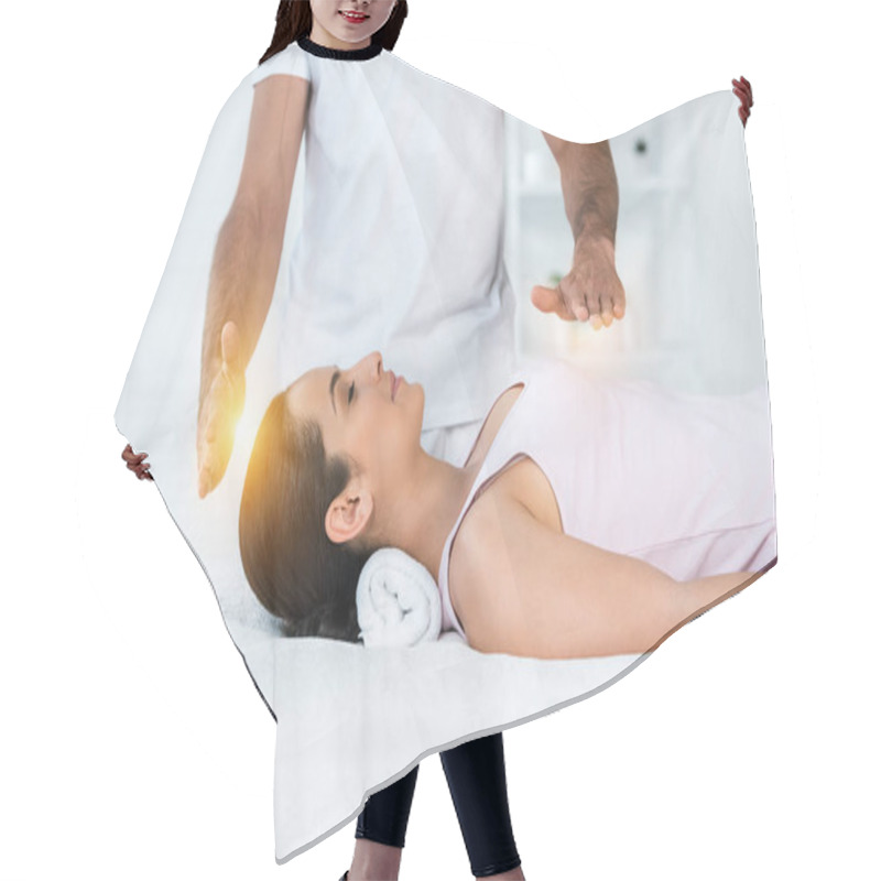 Personality  Cropped View Of Healer Putting Hands Above Body Of Attractive Woman With Closed Eyes Lying On Massage Table Hair Cutting Cape