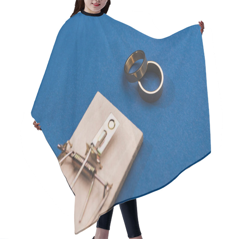 Personality  Selective Focus Of Two Golden Rings With Mouse Trap On Blue Background Hair Cutting Cape