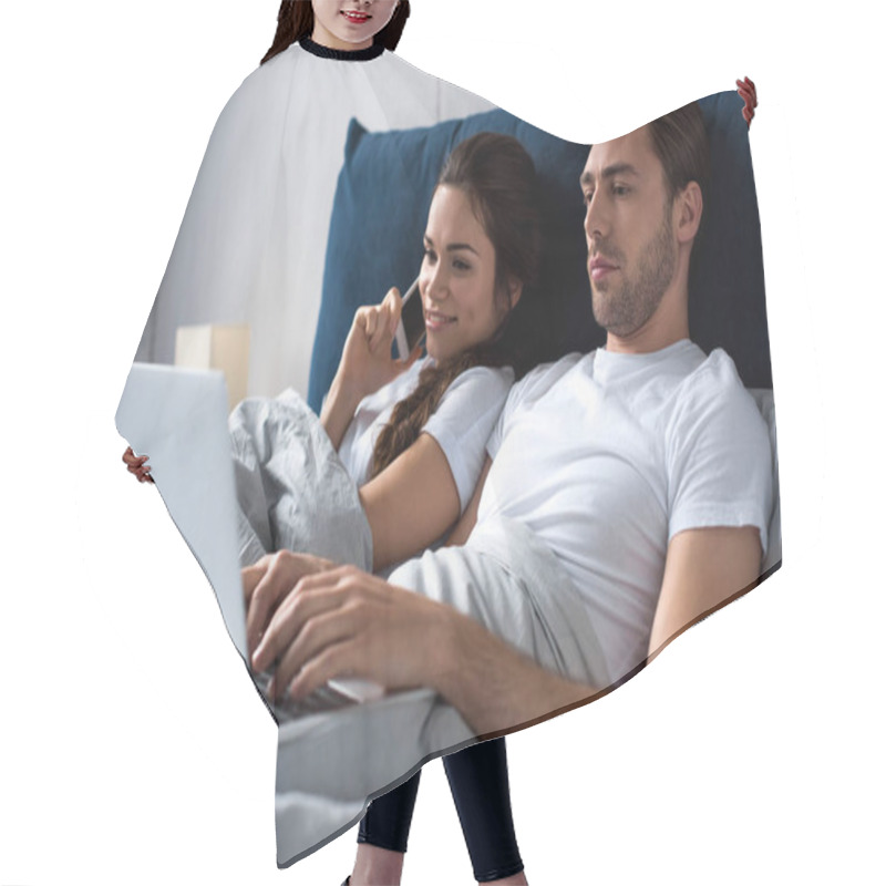 Personality  Young Man And Woman Using Digital Devices While Lying In Bed Hair Cutting Cape