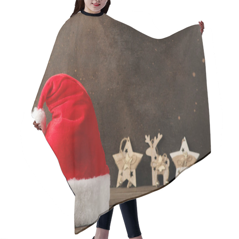 Personality  Red Santa Claus Hat And Garland And New Year's Decor On A Dark Brown Background. With Space For Text. Christmas. New Year. Hair Cutting Cape