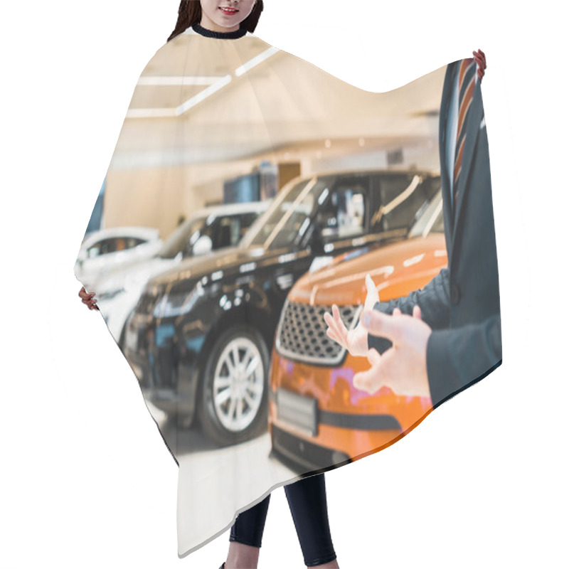 Personality  Cropped Image Of Male Car Dealer Pointing By Hands In Car Salon Hair Cutting Cape