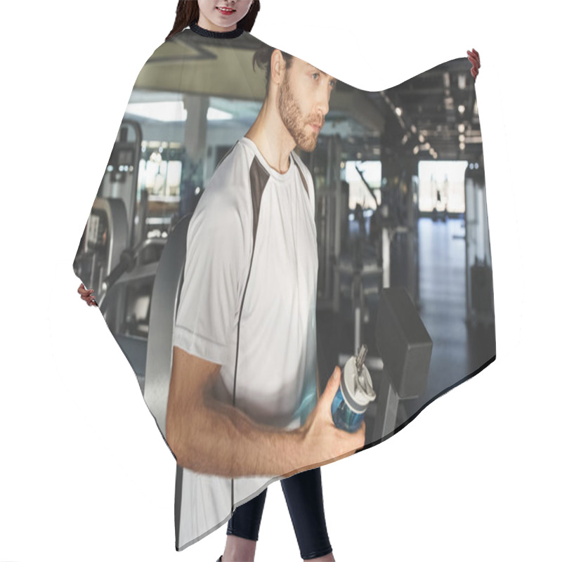 Personality  An Athletic Man In Active Wear Takes A Break, Holding A Bottle Of Water In A Gym Surrounded By Exercise Equipment. Hair Cutting Cape