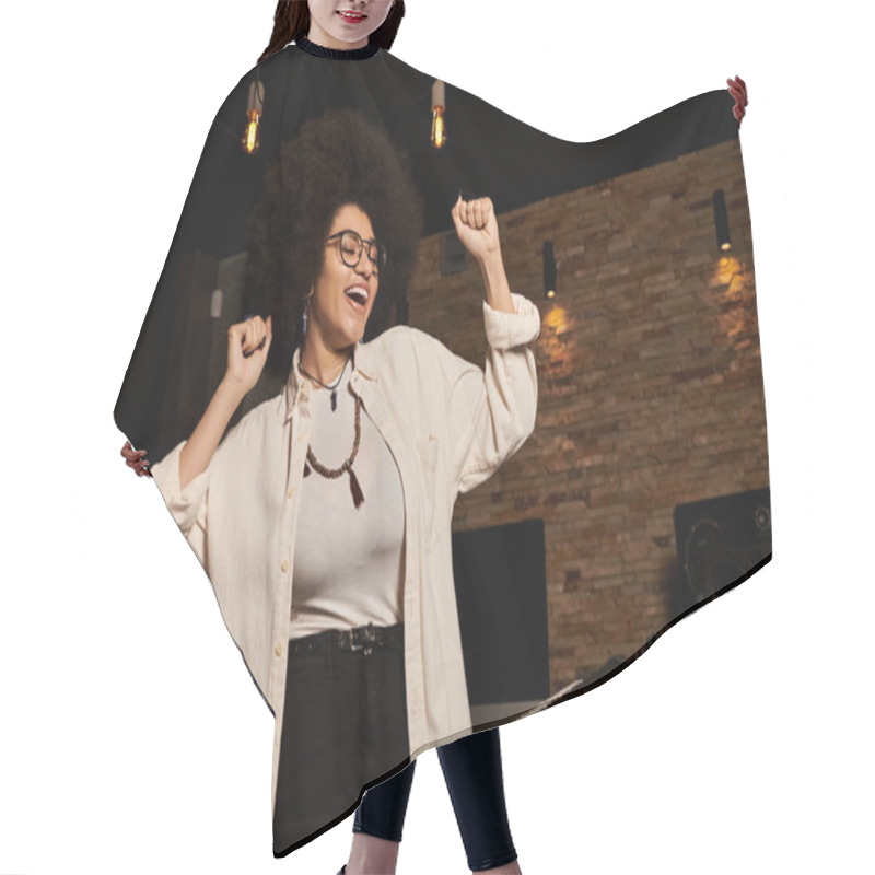 Personality  A Woman Stands Confidently In A Recording Studio, Surrounded By Music Equipment And Instruments. Hair Cutting Cape