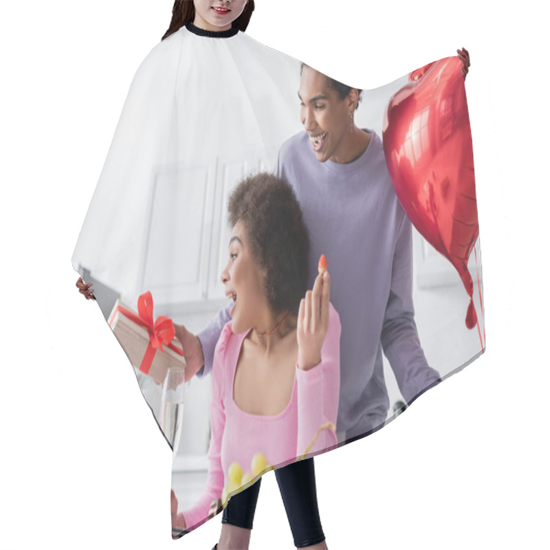 Personality  Happy African American Man Holding Heart-shaped Balloons And Gift Near Girlfriend With Present And Strawberry At Home  Hair Cutting Cape