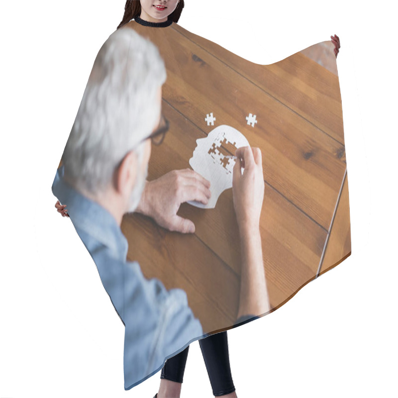 Personality  Overhead View Of Senior Man On Blurred Foreground Folding Puzzle On Table  Hair Cutting Cape