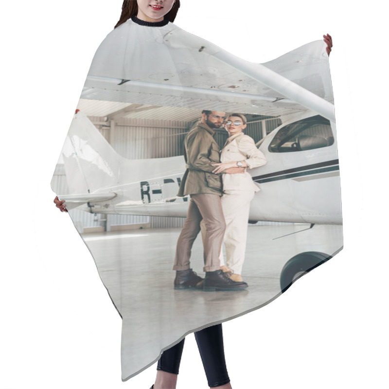 Personality  Young Fashionable Couple In Jacket Embracing Near Plane In Hangar  Hair Cutting Cape