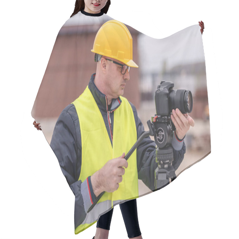 Personality  Caucasian Photographer With Yellow Vest And Helmet Taking Photo At Construction Site. Hair Cutting Cape