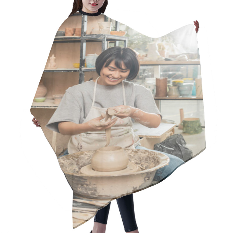 Personality  Positive Young Asian Female Potter In Apron Holding Clay Near Vase On Spinning Pottery Wheel And Wooden Tools And Bowl In Blurred Ceramic Studio, Artisanal Pottery Production And Process Hair Cutting Cape