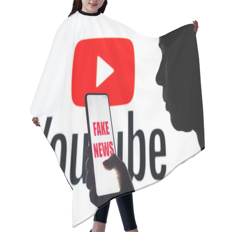 Personality  April 5, 2022, Brazil. In This Photo Illustration, A Woman Holds A Smartphone With The Fake News Logo Displayed On The Screen With The YouTube Logo Displayed In The Background Hair Cutting Cape