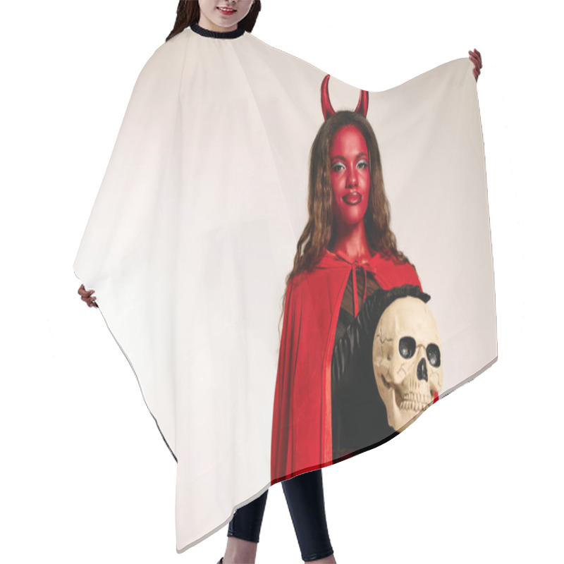 Personality  A Captivating Woman In A Devil Costume Highlights Her Look With A Skull For Halloween. Hair Cutting Cape