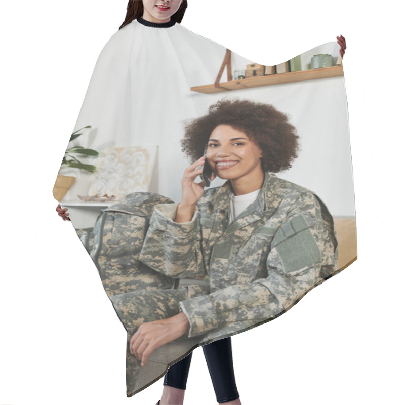 Personality  A Smiling Young Woman In Military Attire Chats On The Phone While Seated In Her Cozy Living Room. Hair Cutting Cape