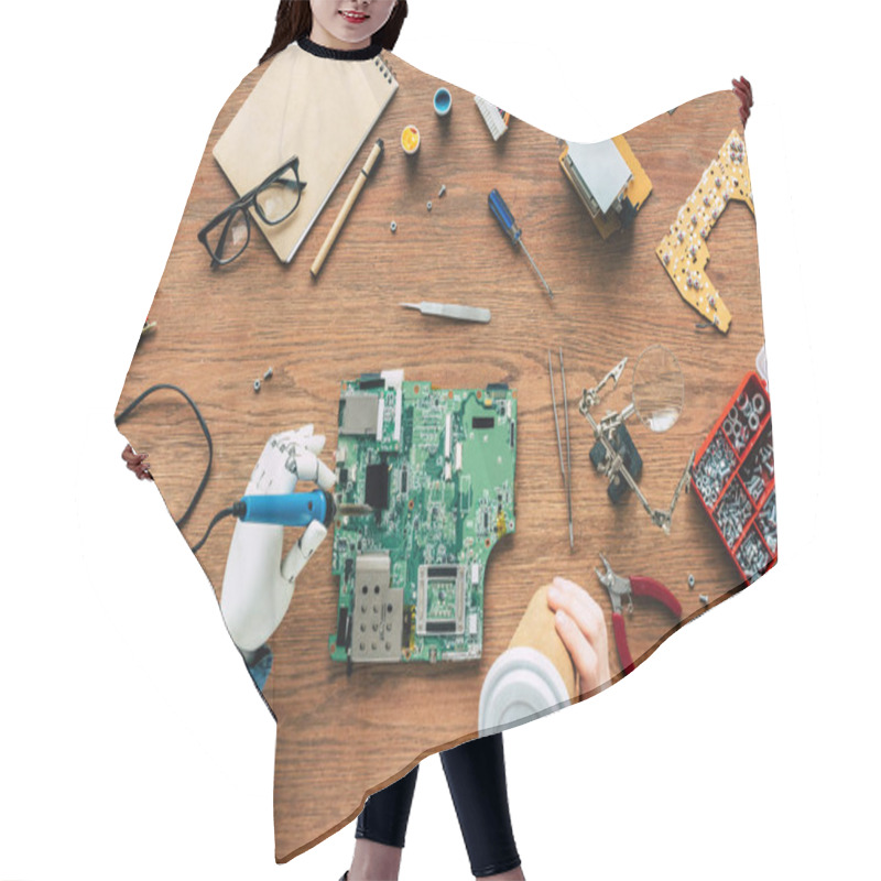 Personality  Cropped Image Of Electronic Engineer With Prosthetic Arm Soldering Motherboard And Holding Paper Cup  Hair Cutting Cape