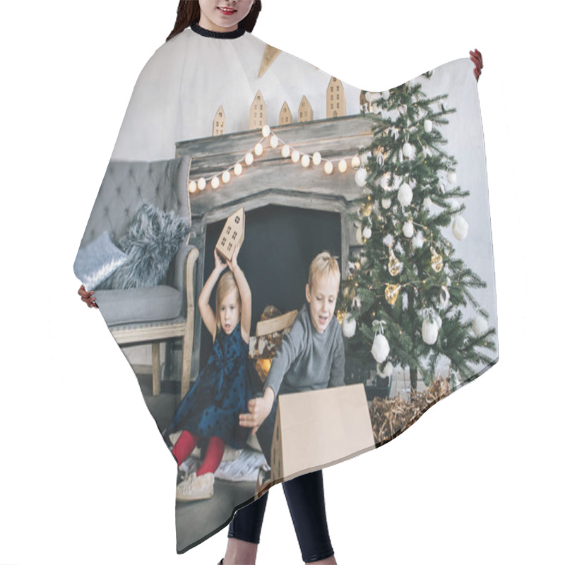 Personality  Children - A Boy And A Girl Are Sitting By The Fireplace, A New Year Tree, Playing With Cardboard Houses, A Cozy Christmas Decor And Children's Emotions Hair Cutting Cape