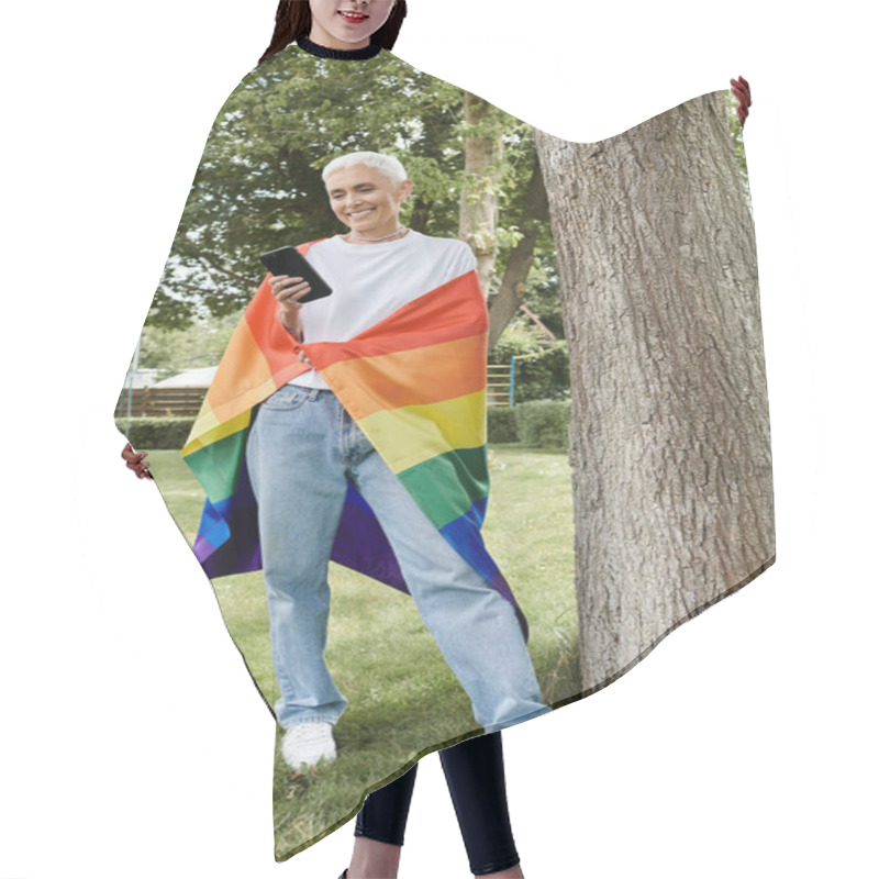 Personality  Mature Woman With Short Hair Stands Proudly Wrapped In A Rainbow Flag While Smiling. Hair Cutting Cape