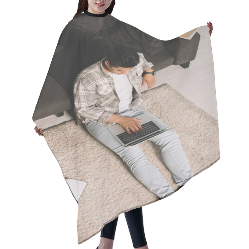 Personality  Overhead View Of Young Man Sitting On Floor Near Couch And Using Laptop At Home Hair Cutting Cape