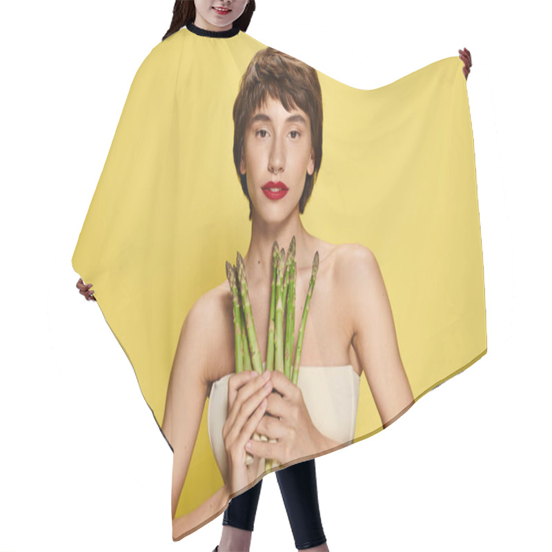 Personality  A Young Woman Holding A Bunch Of Asparagus In Front Of Her Face. Hair Cutting Cape