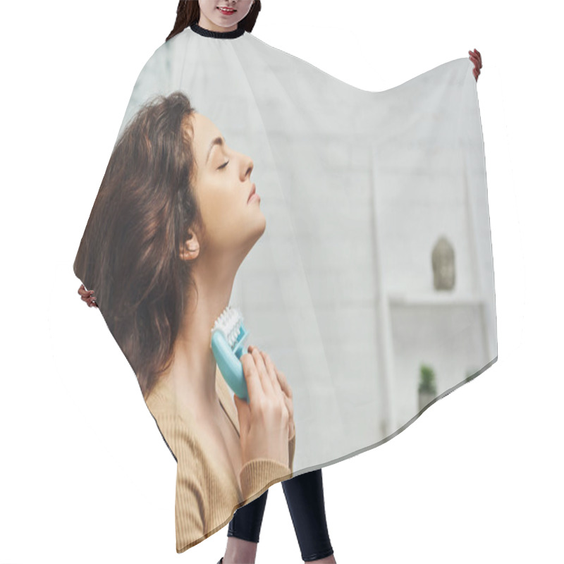 Personality  Side View Of Relaxing Young Brunette Woman In Brown Jumper Massaging Thyroid Gland And Lymphatic System With Handled Massager At Home, Enhancing Self-awareness And Body Relaxation Concept Hair Cutting Cape