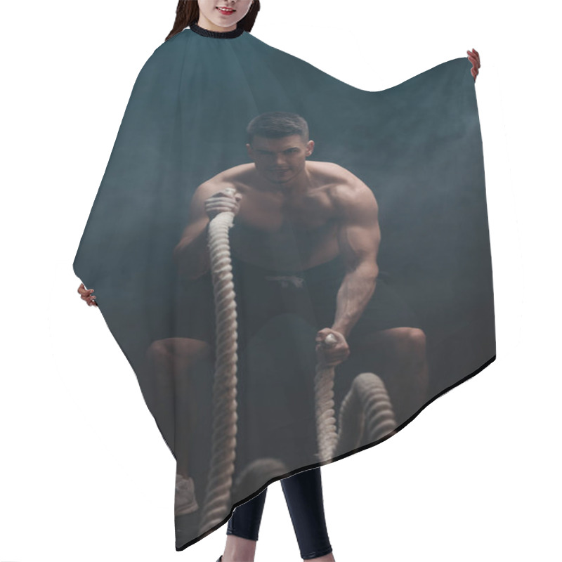 Personality  Sexy Muscular Bodybuilder With Bare Torso Excising With Battle Rope On Black Background With Smoke  Hair Cutting Cape