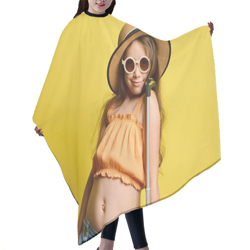 Personality  Cheerful Child Girl Tourist Passenger In Straw Hat, Sunglasses And Summer Clothes, Smiling Looking At Camera, Travelling Abroad, Posing With A Suitcase Bag Isolated Yellow Background. Air Flight. Trip Hair Cutting Cape