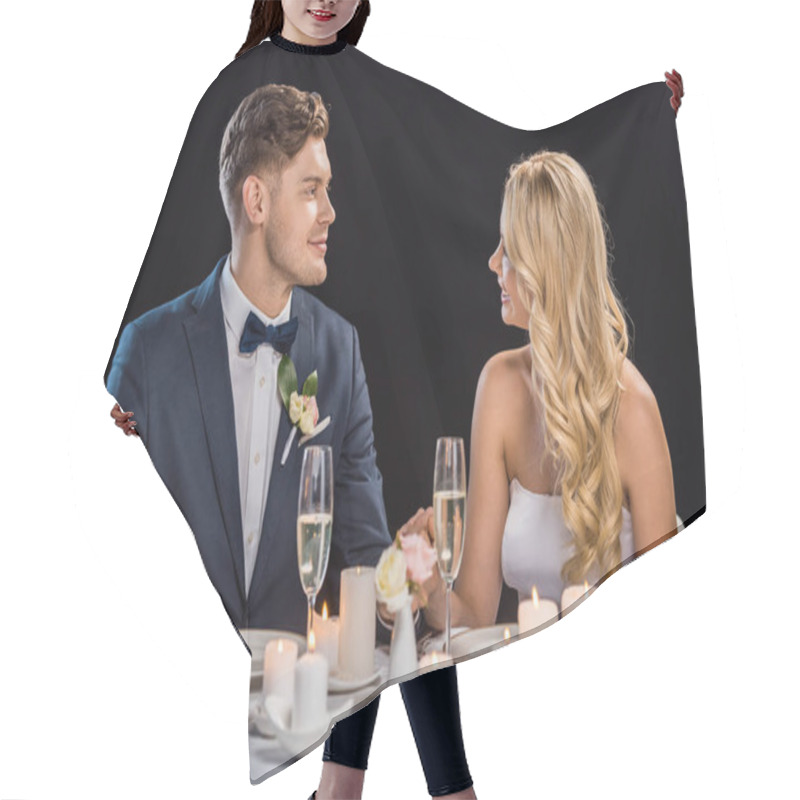 Personality  Happy Young Couple Sitting At Served Table And Looking At Each Other Isolated On Black Hair Cutting Cape