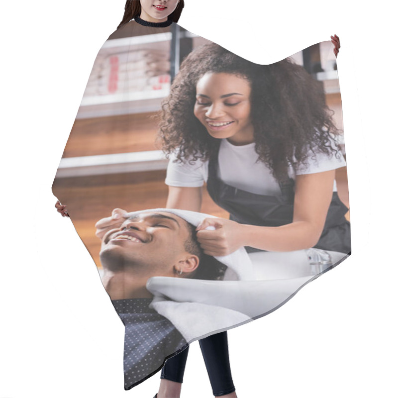 Personality  Smiling African American Hairdresser Holding Towel Near Head Of Client In Salon  Hair Cutting Cape