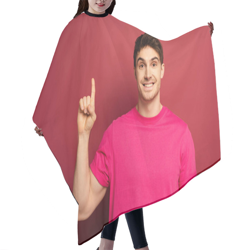 Personality  Portrait Of Smiling Man In Pink T-shirt Pointing Up On Red Hair Cutting Cape