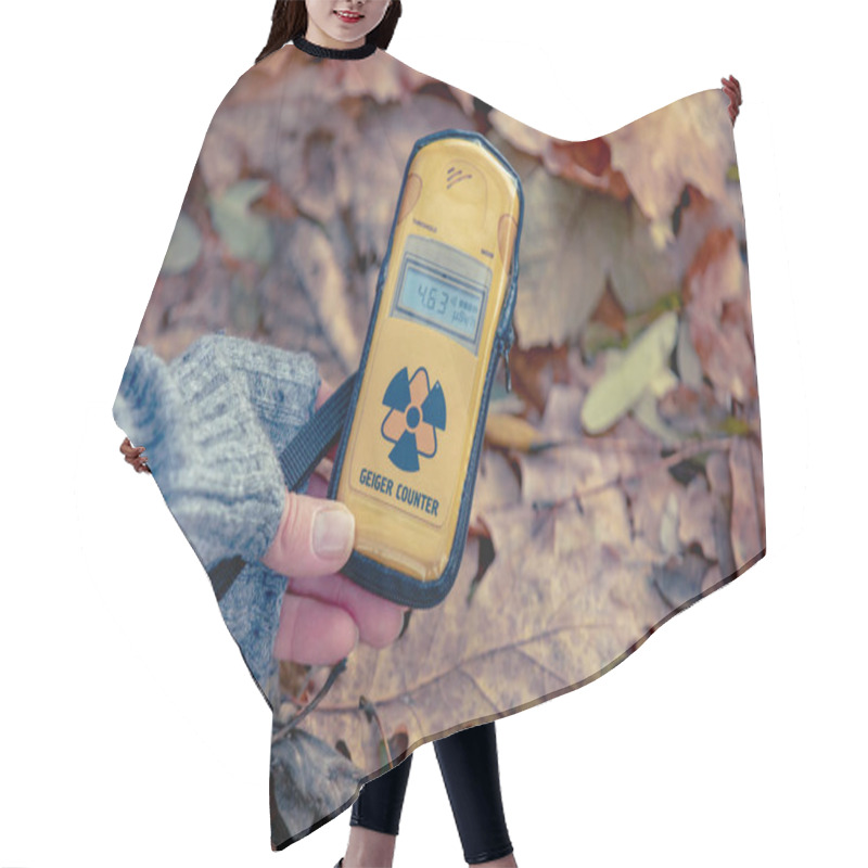 Personality  Dosimeter In A Female Hand On A Background Of Fallen Leaves. Checking Radiation Level With A Personal Dosimeter. Pripyat City In Chernobyl Exclusion Zone, Ukraine Hair Cutting Cape