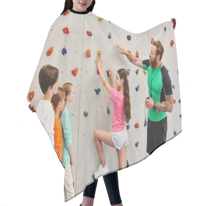 Personality  A Male Teacher Assists A Diverse Group Of Children As They Learn How To Climb On A Colorful Climbing Wall In A Vibrant Classroom Setting. Hair Cutting Cape