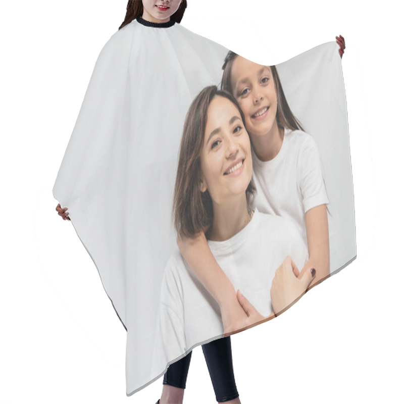 Personality  Brunette Preteen Kid Hugging Happy Mother With Short Hair While Posing Together In White T-shirts And Looking At Camera On Grey Background, International Children's Day  Hair Cutting Cape