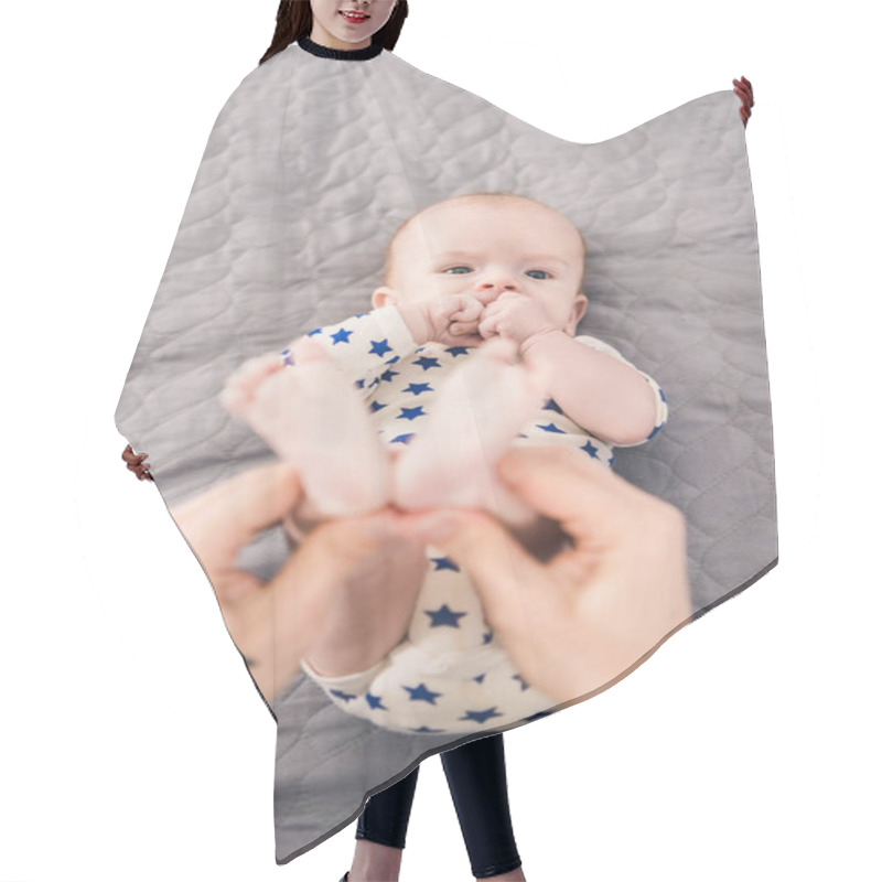 Personality  Cropped Shot Of Father Holding Little Sons Feet In Hands Hair Cutting Cape