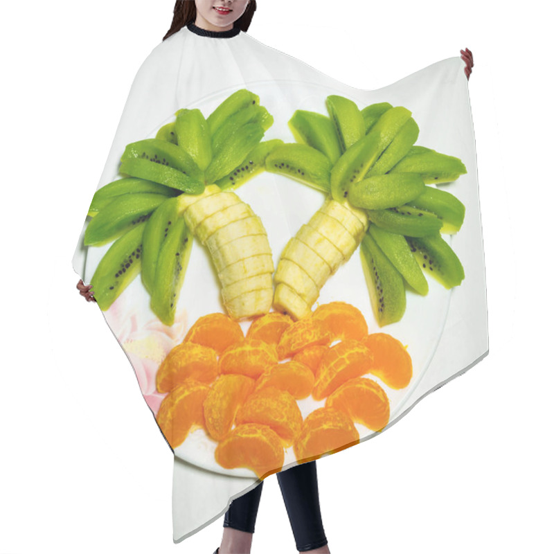 Personality  A Playful Fruit Arrangement Features Banana Trunks Topped With Green Kiwi Leaves, Surrounded By Vibrant Orange Slices, Creating A Tropical Look On A White Plate. Hair Cutting Cape