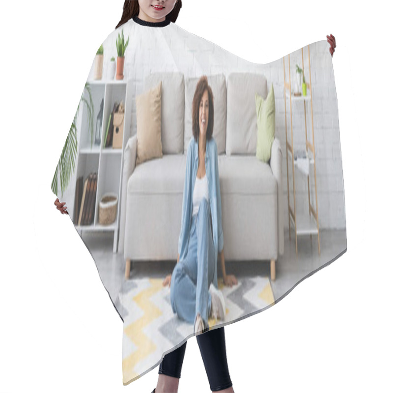 Personality  Cheerful African American Woman Sitting On Rug With Pattern Near Modern Sofa In Living Room, Banner Hair Cutting Cape