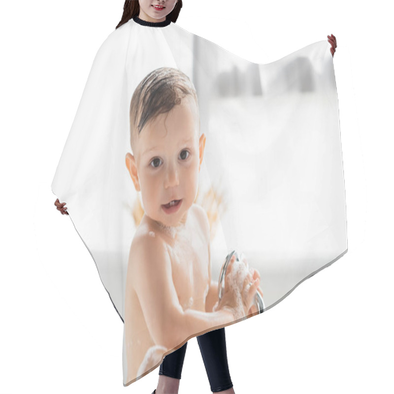 Personality  Wet Toddler Boy With Bath Foam On Body Looking At Camera While Holding Shower Head  Hair Cutting Cape