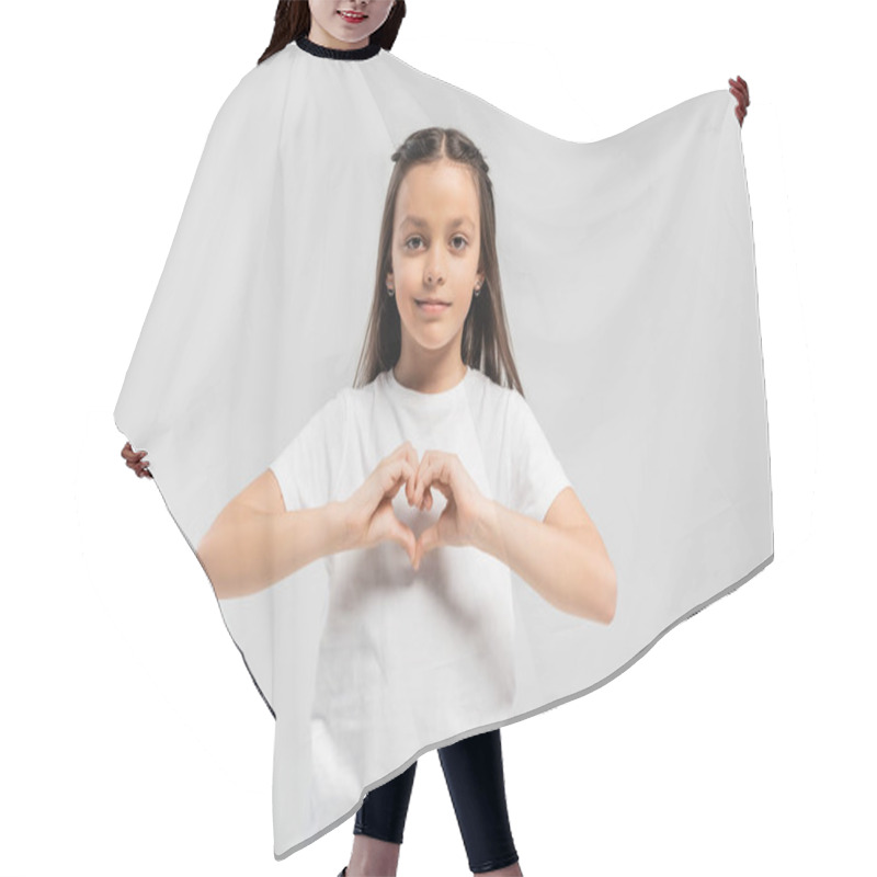 Personality  Happy Preteen Girl With Long Brunette Hair Standing In White T-shirt And Showing Heart Gesture With Hands Isolated On Grey Background, Child Protection Day Holiday  Hair Cutting Cape