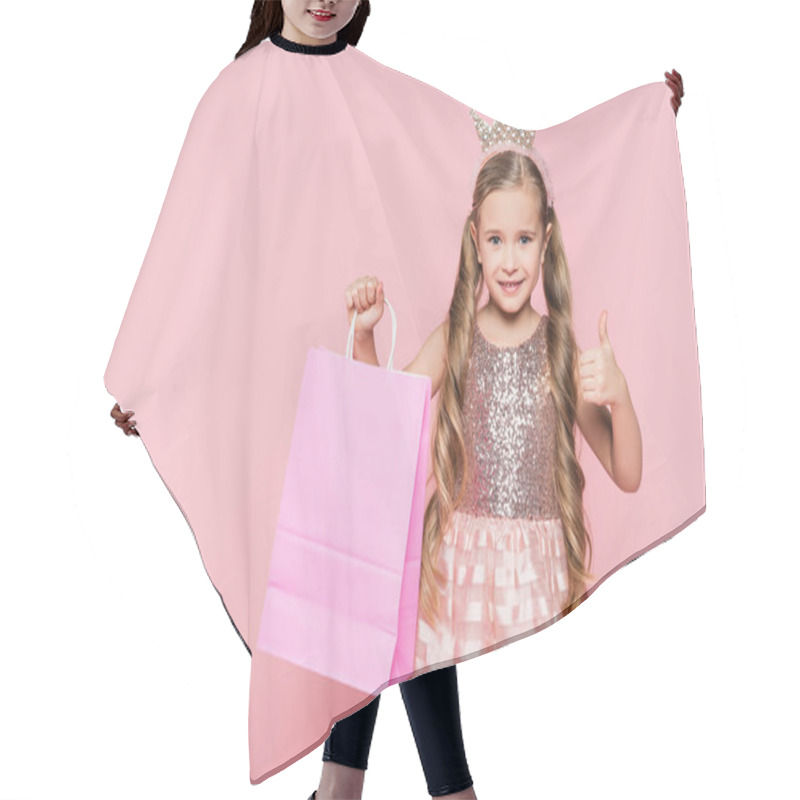 Personality  Cheerful Little Girl In Dress And Crown Holding Shopping Bag And Showing Thumb Up Isolated On Pink  Hair Cutting Cape