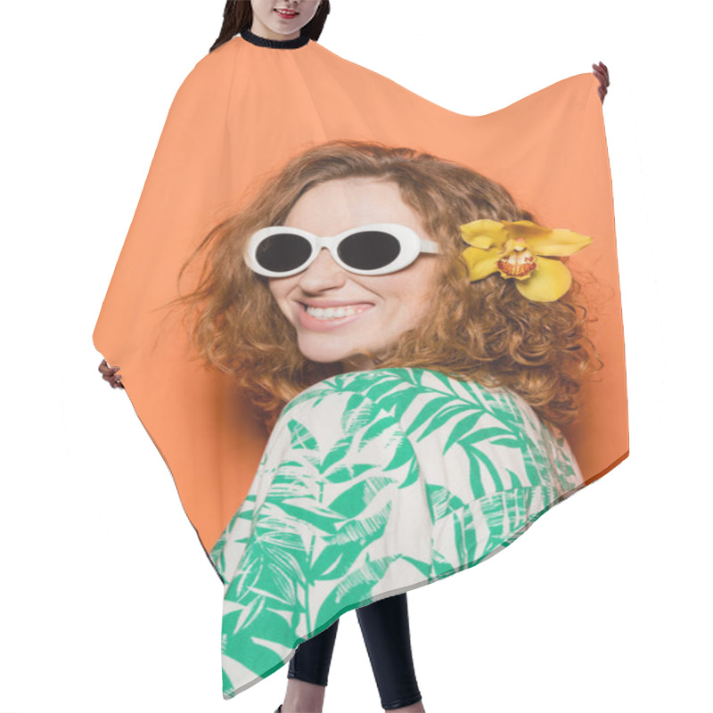 Personality  Positive Young Woman With Red Hair And Orchid Flower Posing In Sunglasses And Blouse With Floral Print On Orange Background, Summer Casual And Fashion Concept, Youth Culture Hair Cutting Cape