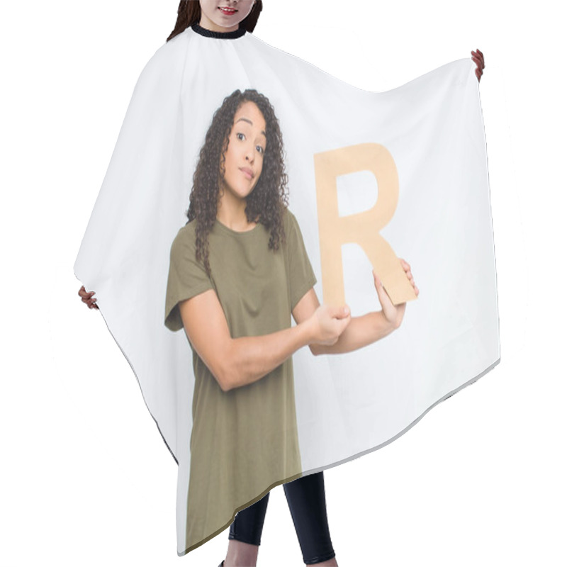 Personality  Young Pretty Latin Woman Confused, Doubtful, Thinking, Holding The Letter R Of The Alphabet To Form A Word Or A Sentence. Hair Cutting Cape